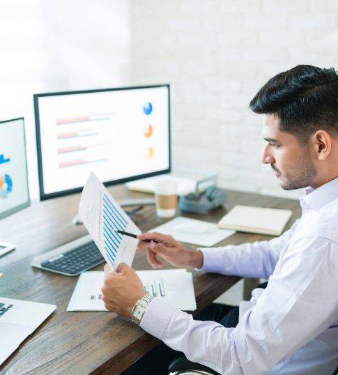 handsome-latin-businessman-examining-sales-data-while-working-home-min